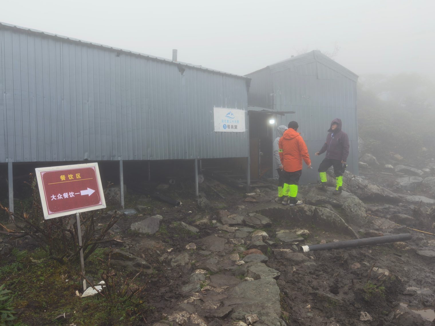 Base camp canteen: metal buildings and a sign pointing to the dining area