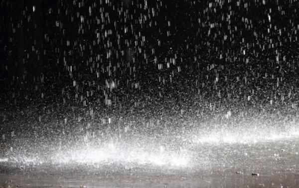 Raindrops lit by lamplight at night