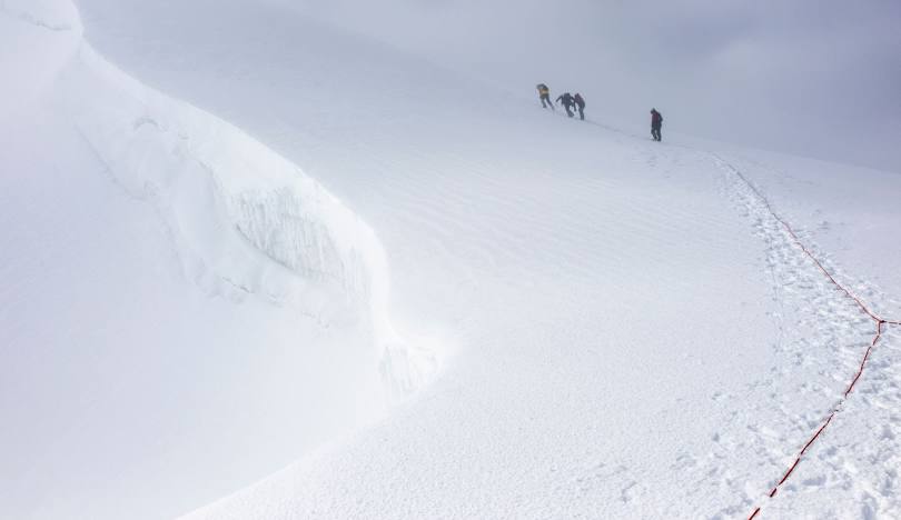 Climbers following a fixed rope on Haba Snow Mountain